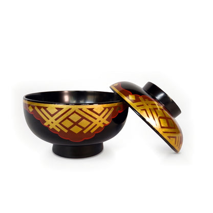 The lid leans against the right side of the open bowl, its gold lattice on red clouds facing out.