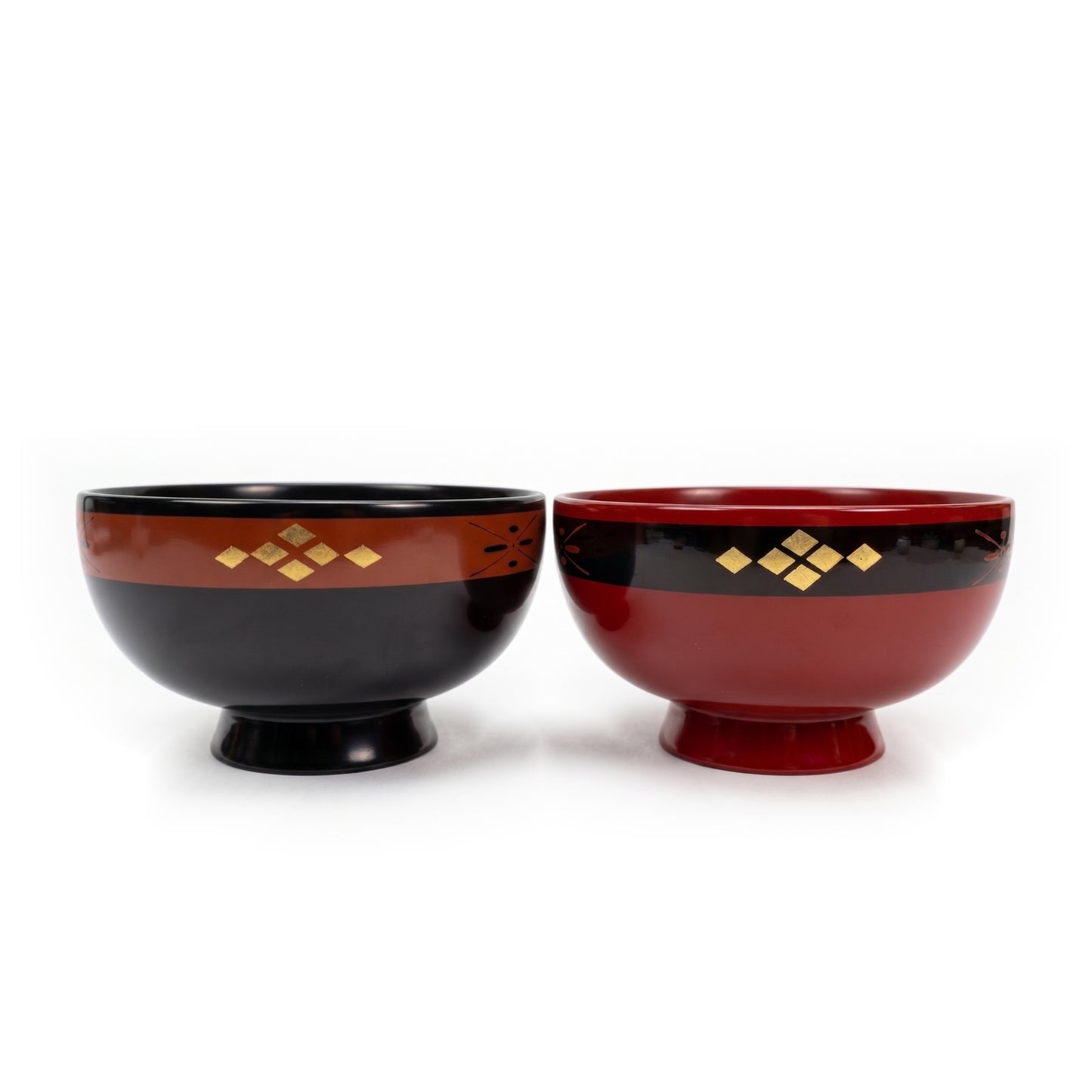 A black lacquer bowl and a red lacquer bowl side by side, each on a high foot, with a gold-diamond band near the rim.