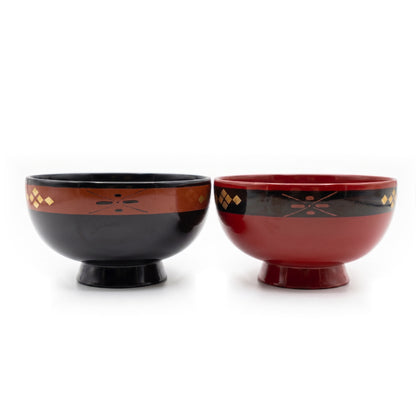 The same black and red lacquer bowl pair from a closer side view, full bowls and pedestal feet still visible.