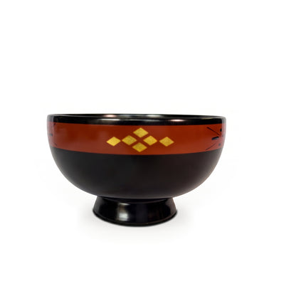 A black lacquer bowl on a high foot, with a rust-toned rim band showing gold diamonds and a thin cross-and-dot motif.