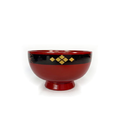 A red lacquer bowl on a high foot, with six gold-leaf diamonds centered on its black rim band.