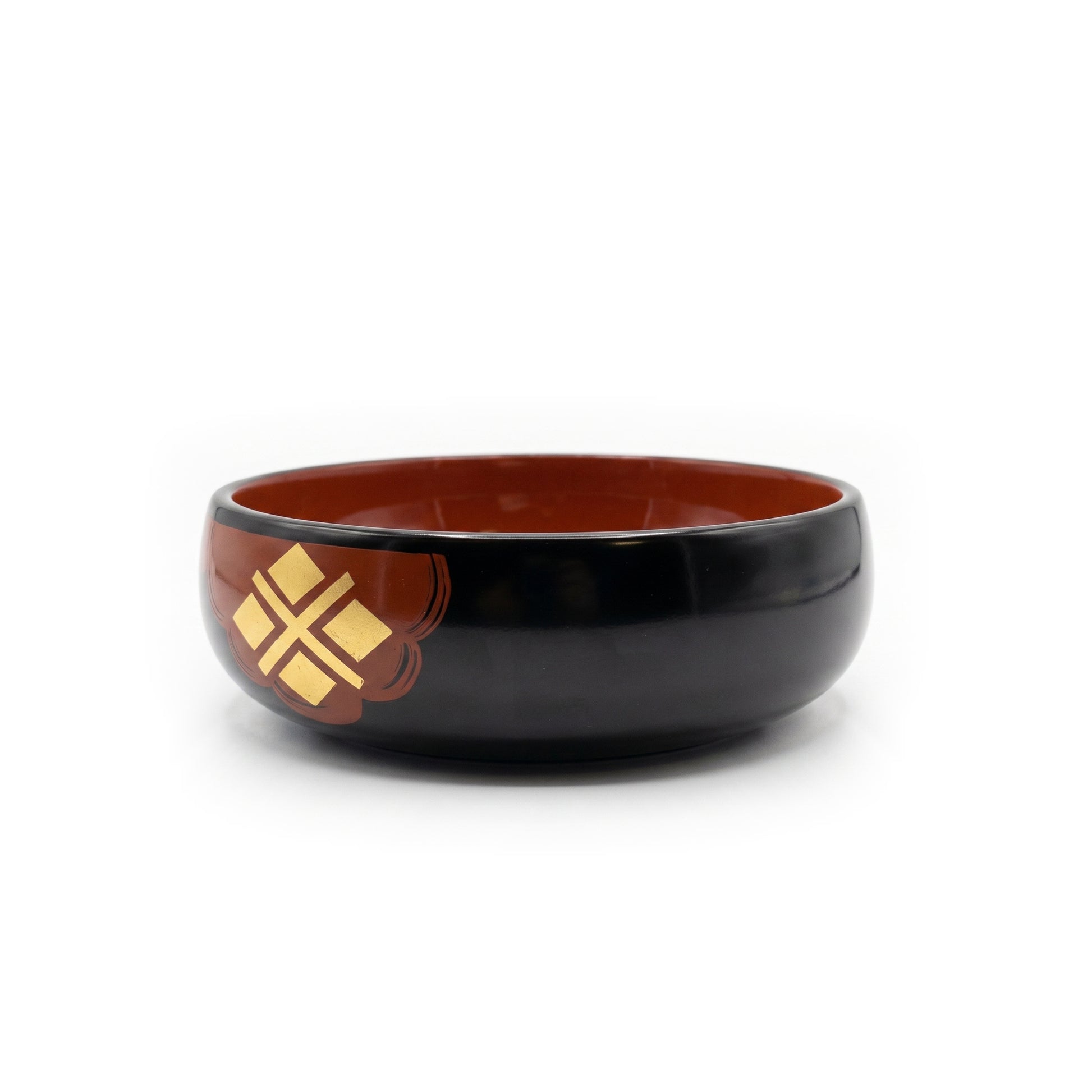 The bowl from a raised angle, its deep red interior open to view, with a gold four-diamond cross on a red patch at the left.
