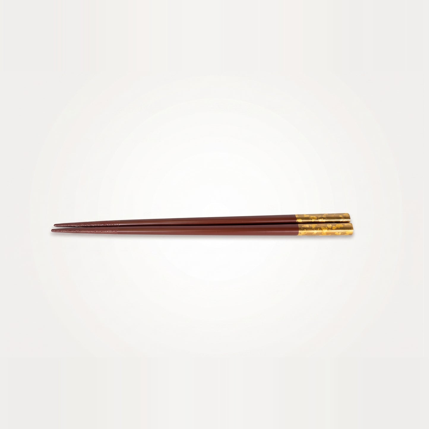 Viewed alone, the deep red lacquer pair runs the full length from a fine tip to its gold-leaf grip end.