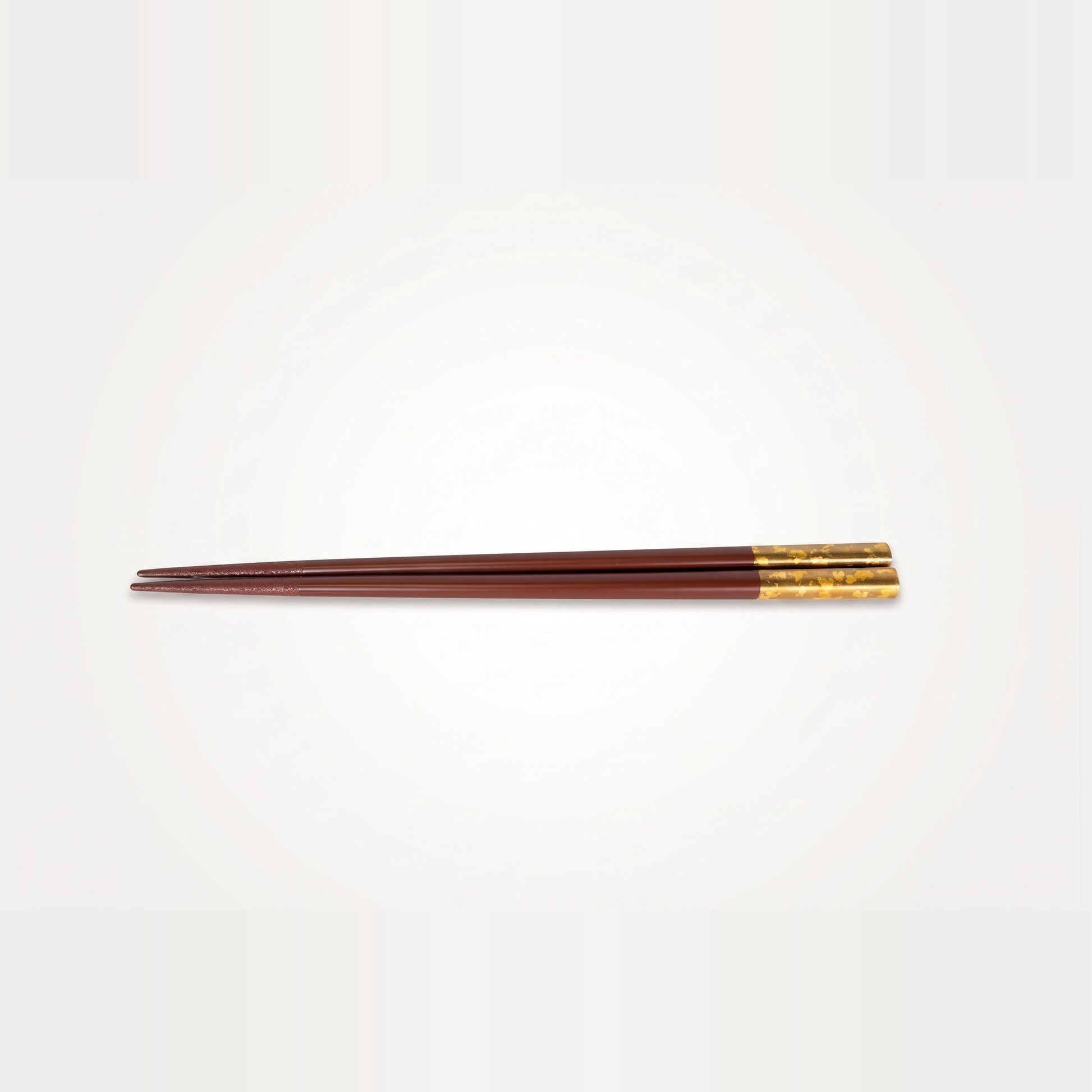 Viewed alone, the deep red lacquer pair runs the full length from a fine tip to its gold-leaf grip end.