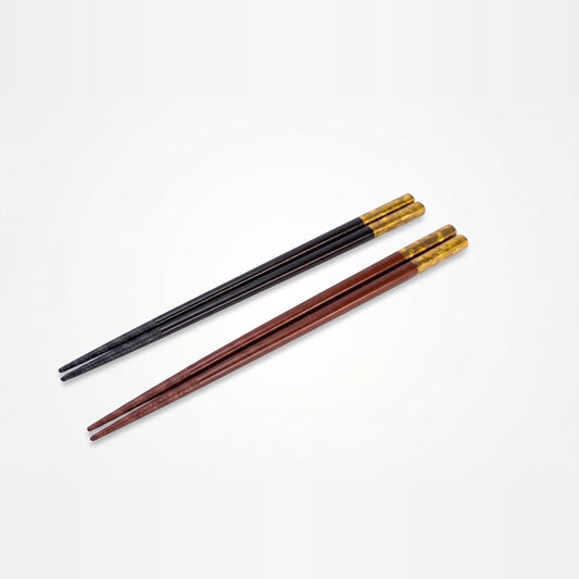 Black and deep red lacquer chopstick pairs arranged diagonally, angled to show the mottled gold leaf near their grip ends.