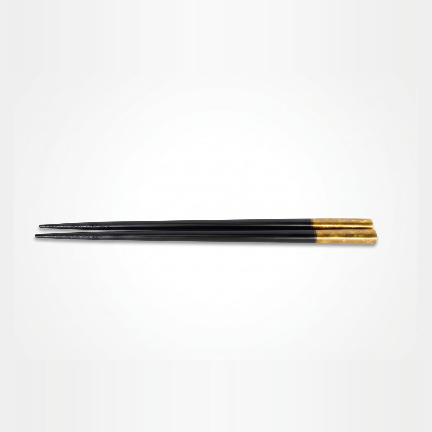 A single pair finished entirely in black lacquer, tapering from a fine tip to a mottled gold-leaf grip end.