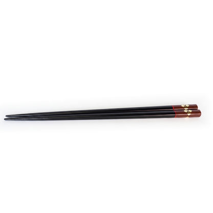 The black pair, the handle end finished in bengara lacquer with gold diamonds, a thin red line where the two meet.