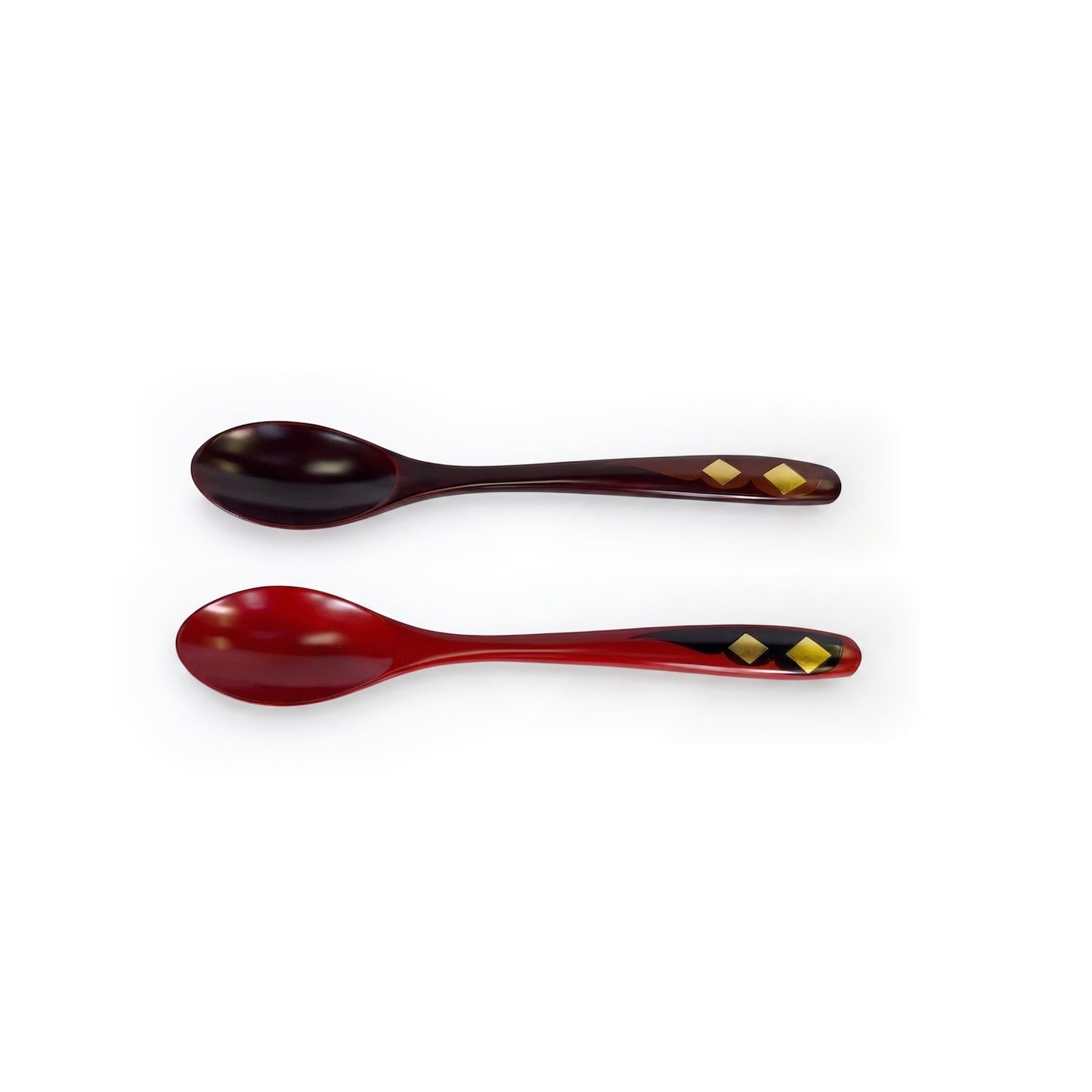 Two lacquer spoons lying parallel, bowls to the left, one dark maroon and one red, each with two gold diamonds on the handle.