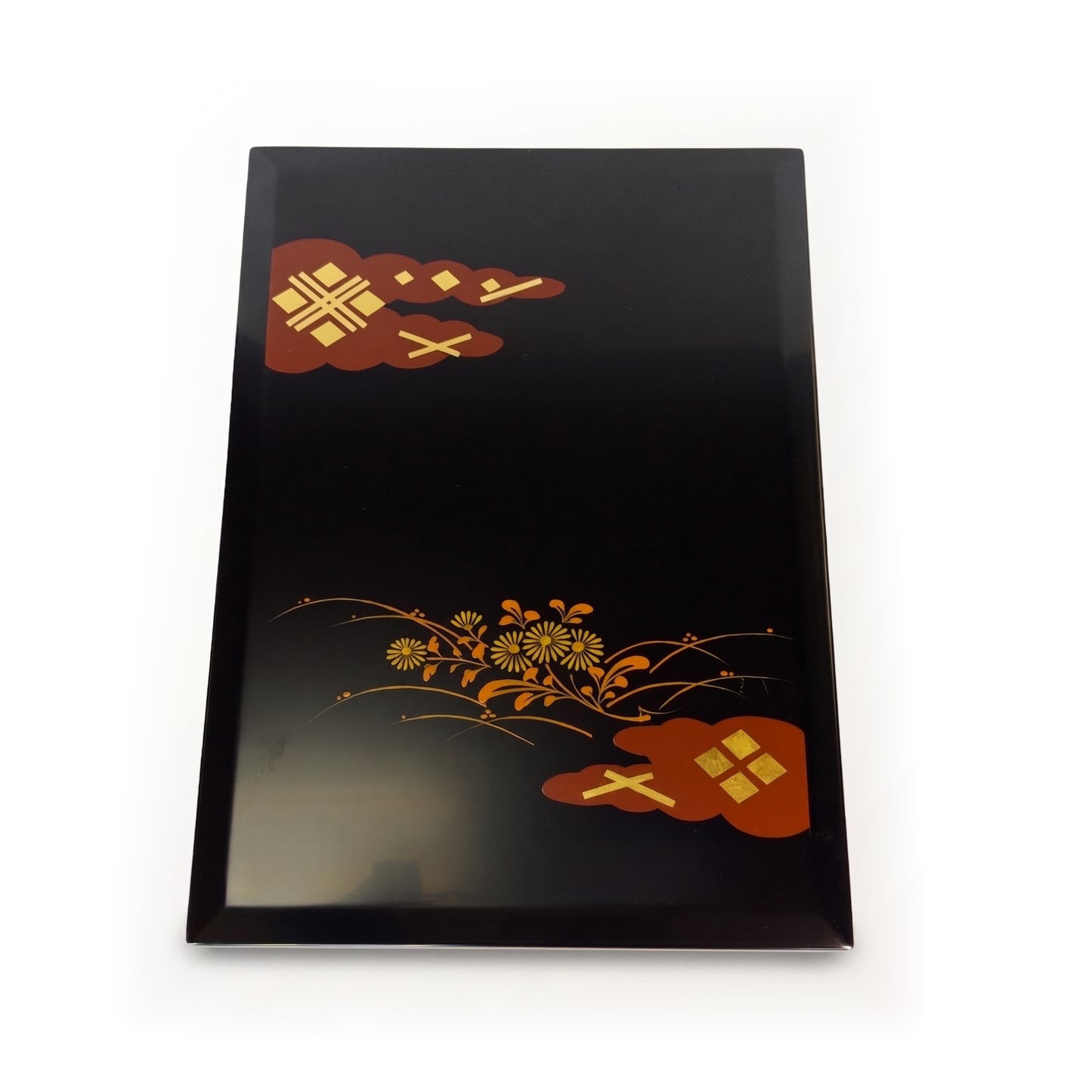 The box lid seen from above, a spray of chrysanthemums across the black centre and red clouds with gold at two corners.